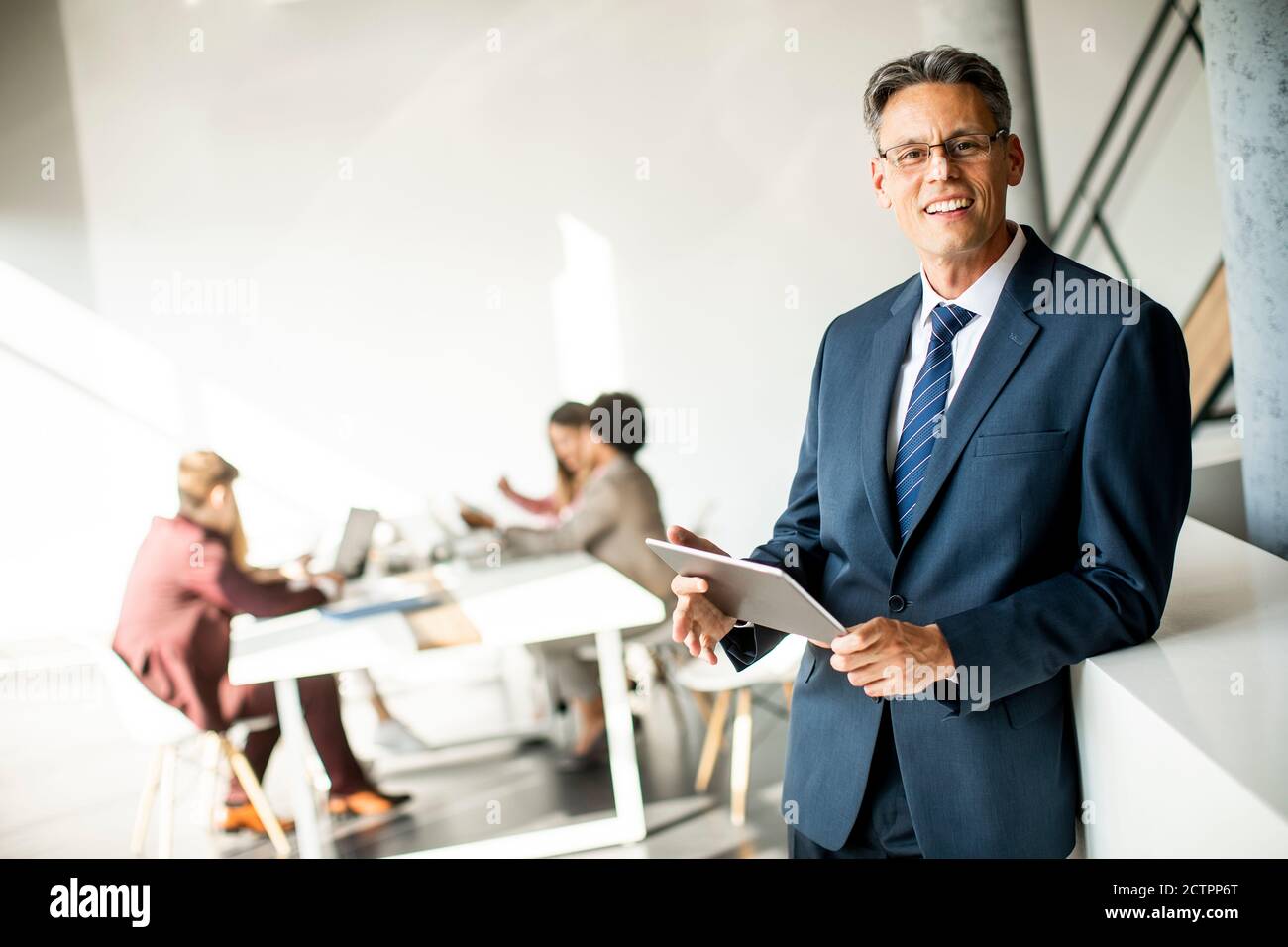 Handsome businessman using his digital tablet in the office Stock Photo ...