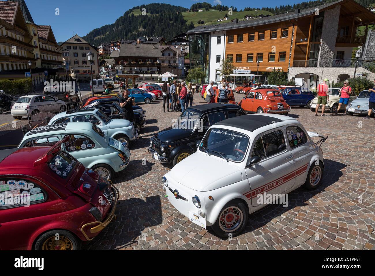 A rally of vintage Fiat 500 cars parks up in the village square of Selva Val Gardena, Italy. Stock Photo