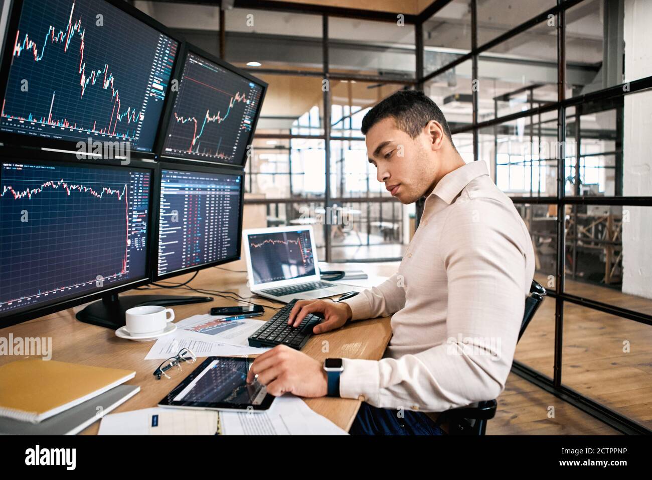Stock Traiding. Trader sitting at office in front of monitors with data  using digital tablet monitoring interpreting and analyzing cryptocurrency  Stock Photo - Alamy