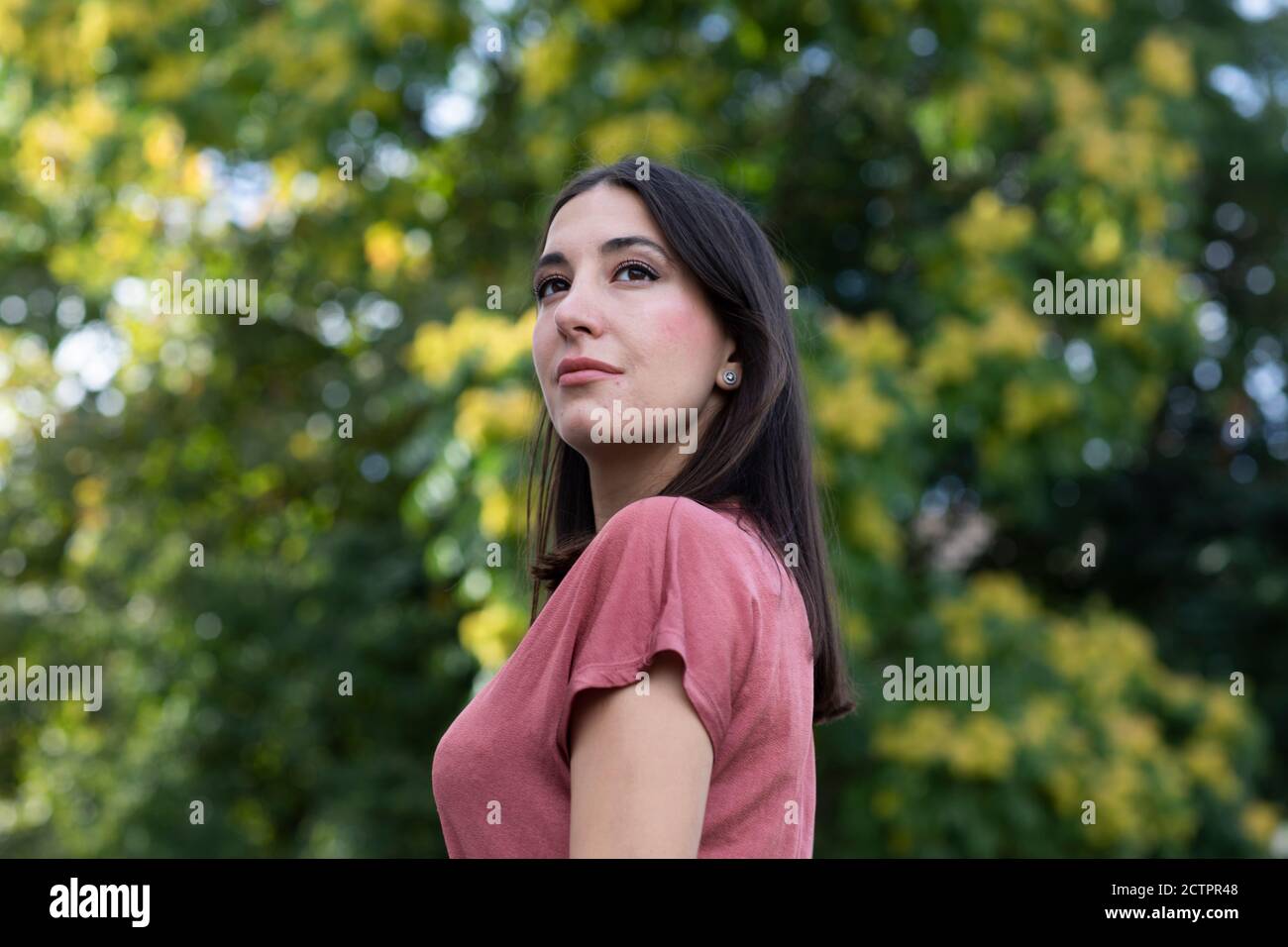 Woman wearing dusty pink top and standing outdoors Stock Photo