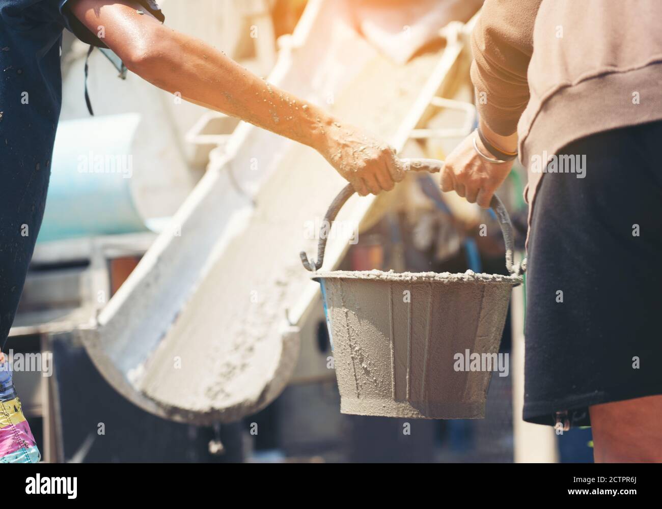 Construction workers helped cement bucket loaders to be introduced into a points set. Stock Photo