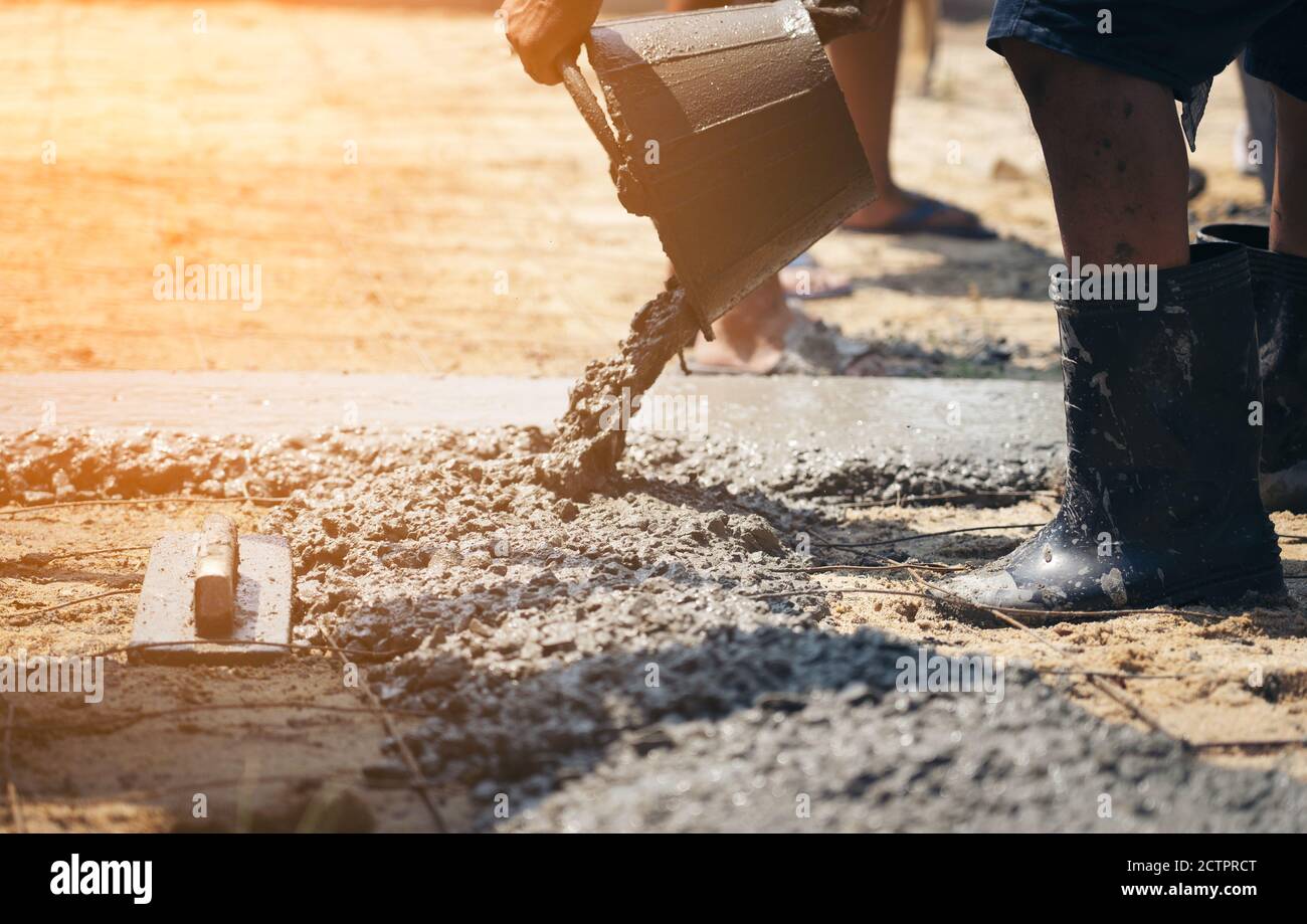 Construction workers helped cement bucket loaders to be introduced into a points set. Stock Photo
