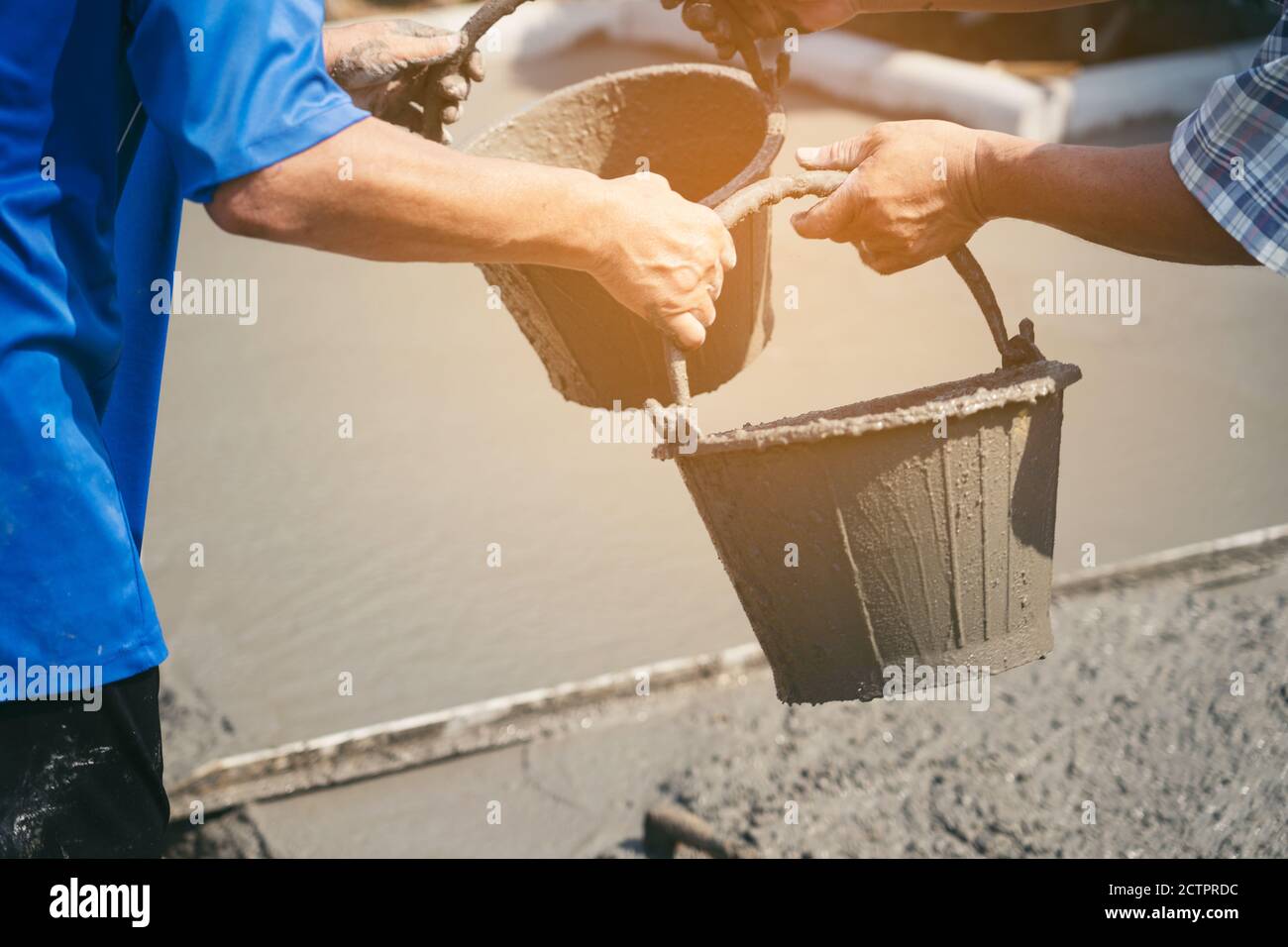 Construction workers helped cement bucket loaders to be introduced into a points set. Stock Photo