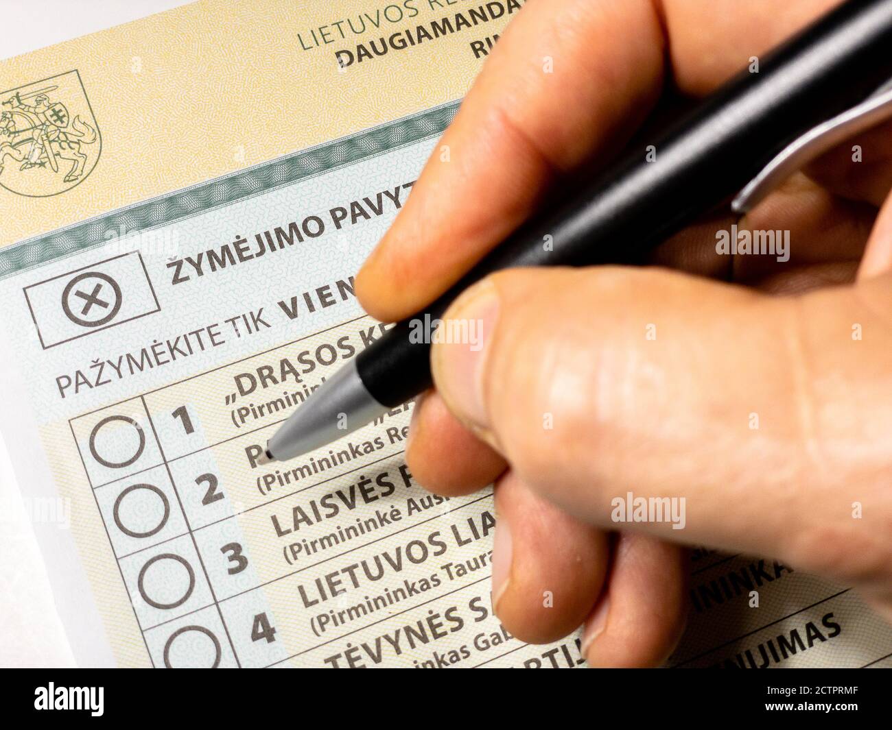 Close up multi-mandate voting ballot for for 2020 Lithuanian Seimas parliamentary elections with hand holding black pen Stock Photo