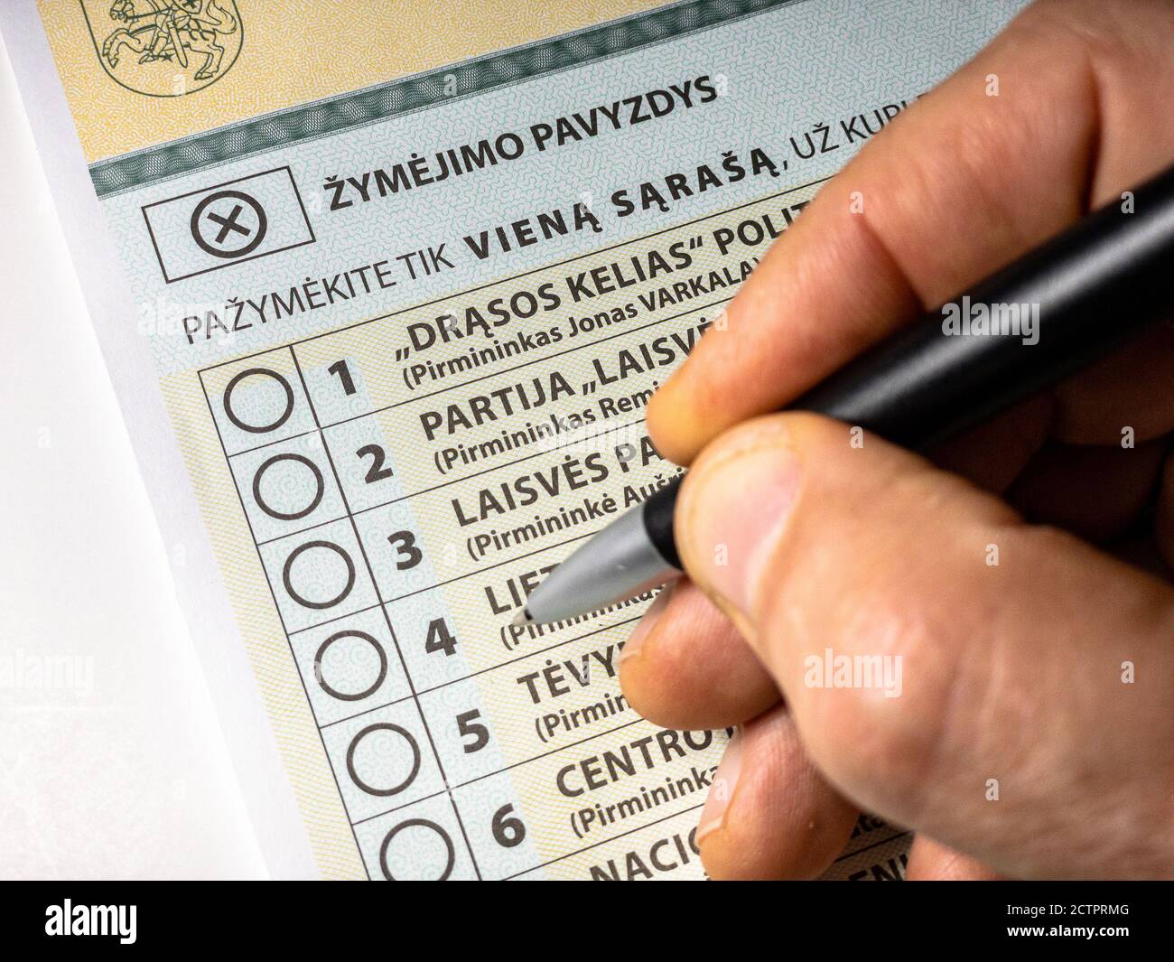 Close up multi-mandate voting ballot for for 2020 Lithuanian Seimas parliamentary elections with hand holding black pen Stock Photo