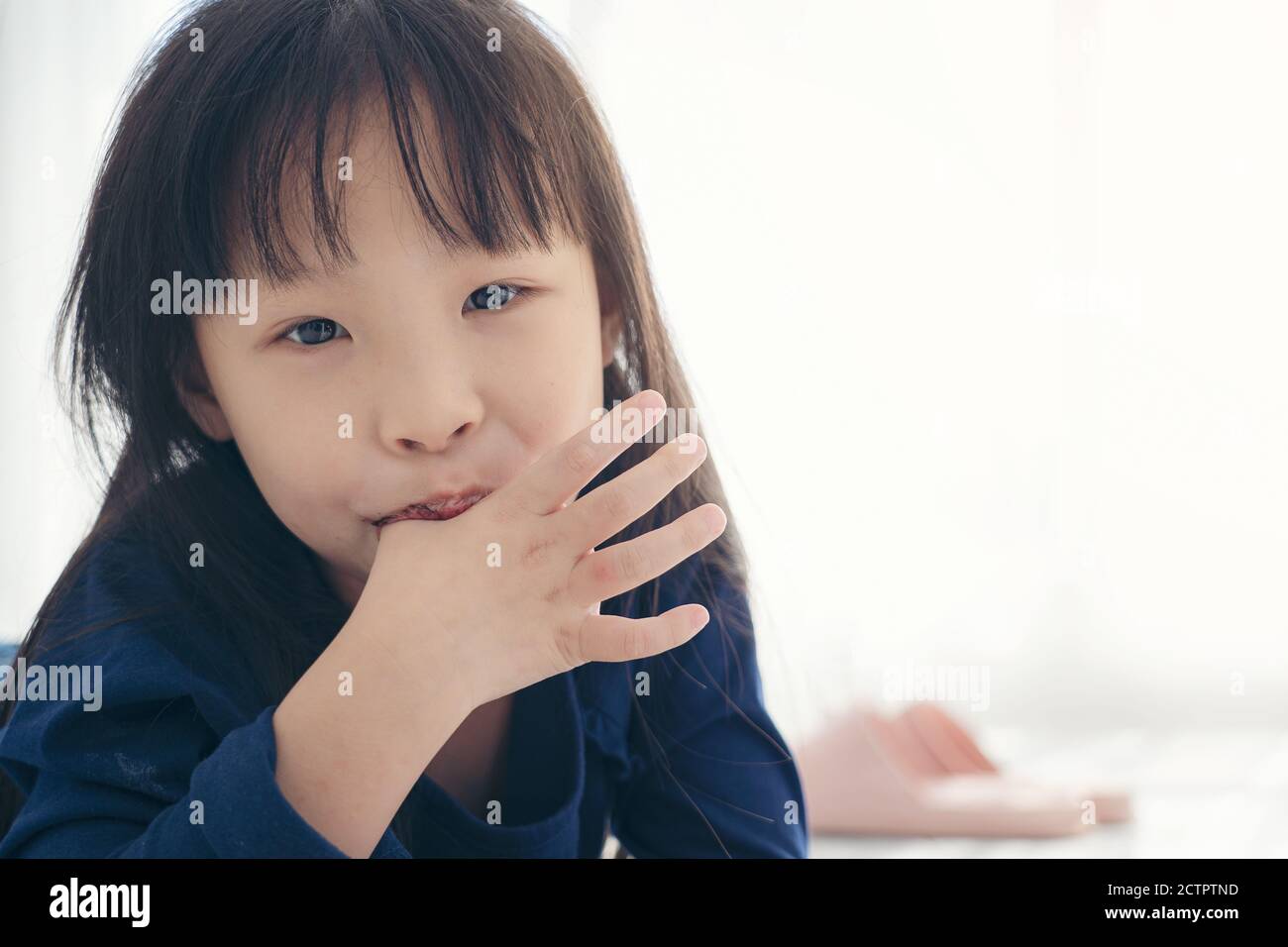 Asian kid cute girll sucking the finger her thumb Stock Photo