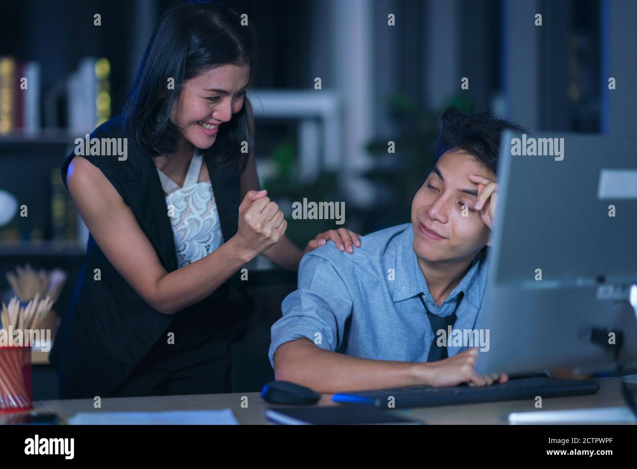 Businesspeople in the office at night working late, Two young
