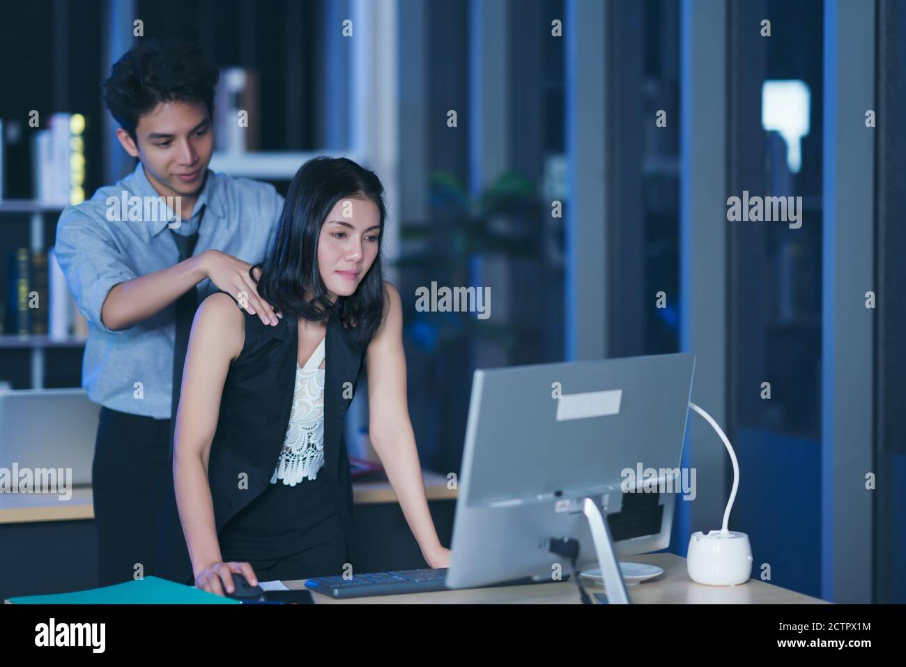 Businesspeople in the office at night working late, Two young