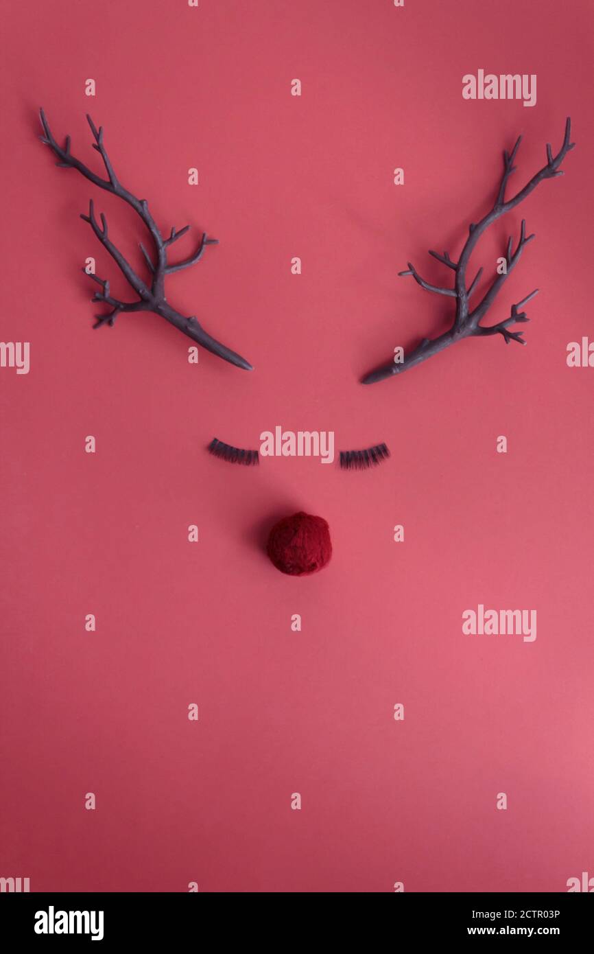 Christmas reindeer concept with red nose, antlers and eyelashes on pink ...