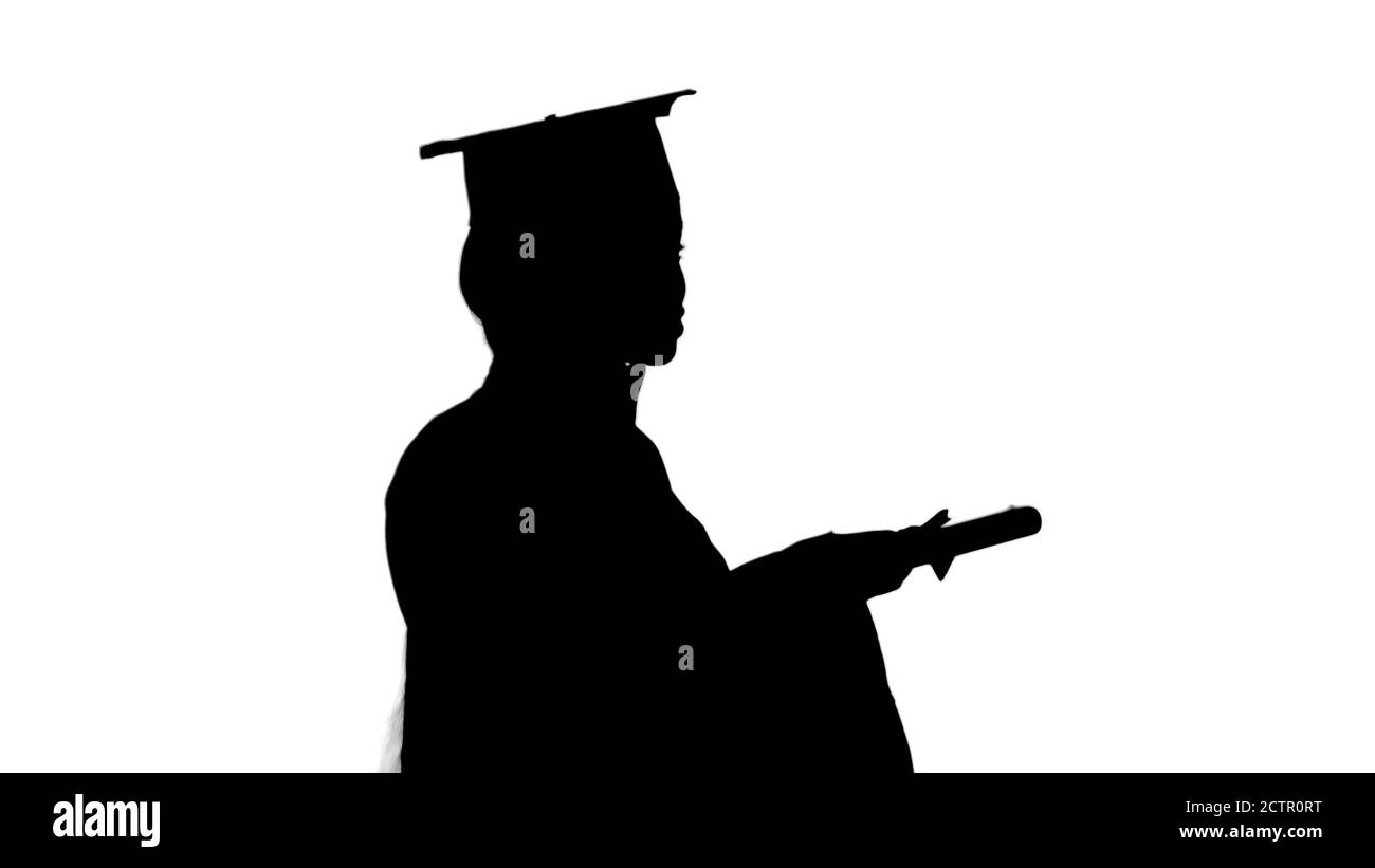 African American female student in graduation robe talking on th Stock Photo