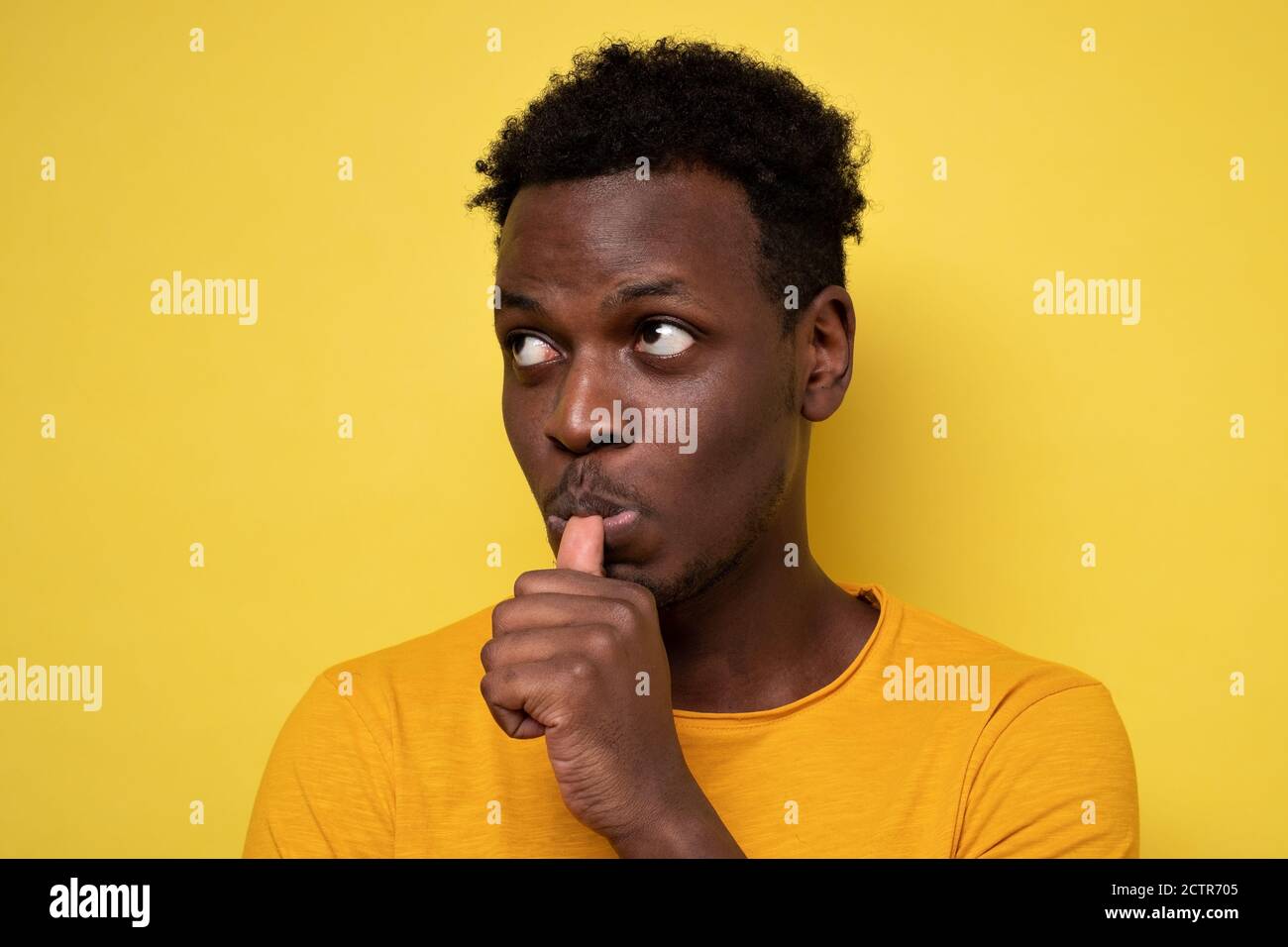 Man with finger in mouth sucking thumb or biting fingernail in stress Stock Photo