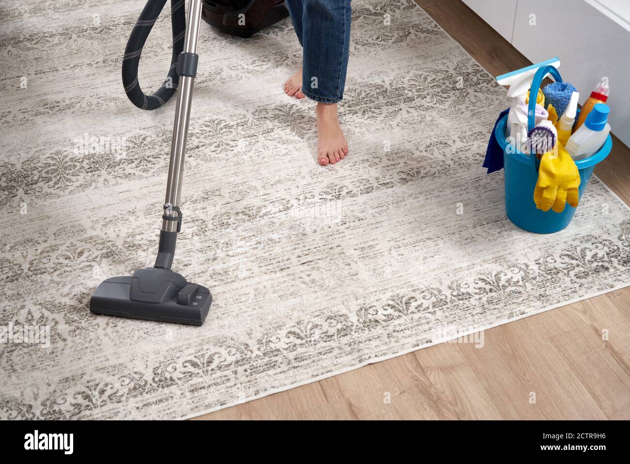 Woman cleaning the carpet with vacuum cleaner in the living room Stock ...