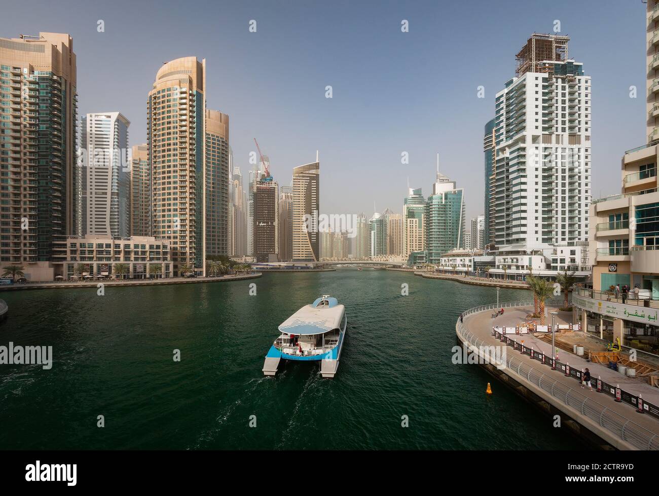 A catamaran-style yacht passes through the marina giving tourists views of the skyscrapers in Dubai, United Arab Emirates (UAE) Stock Photo