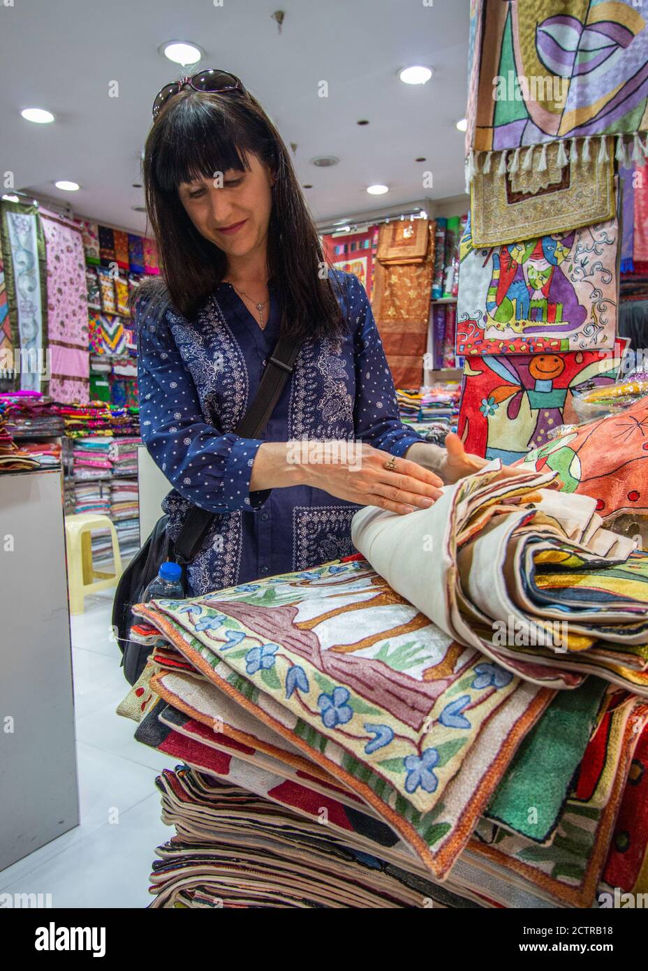 Tourist shopping for pillow cover in souk in Dubai, United Arab