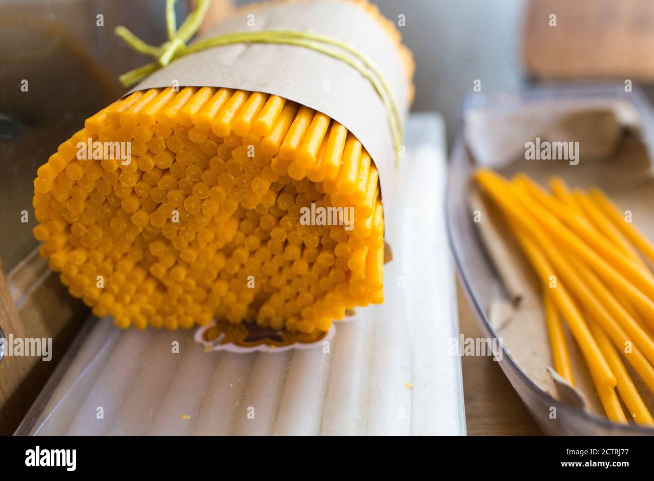 A bundle of votive candles wrapped in a pice of paper, tied with string for sale in an Armenian monastery. Stock Photo