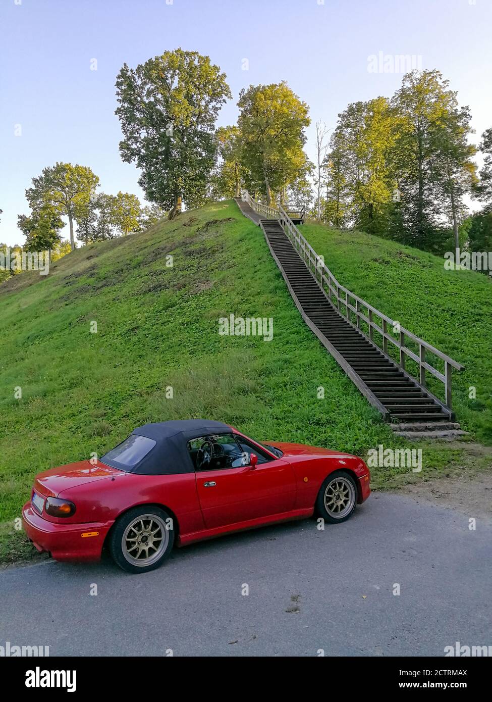 Zemosios Panemunes mound  with wooden stairs and modern car parked close by.  Travel concept Stock Photo