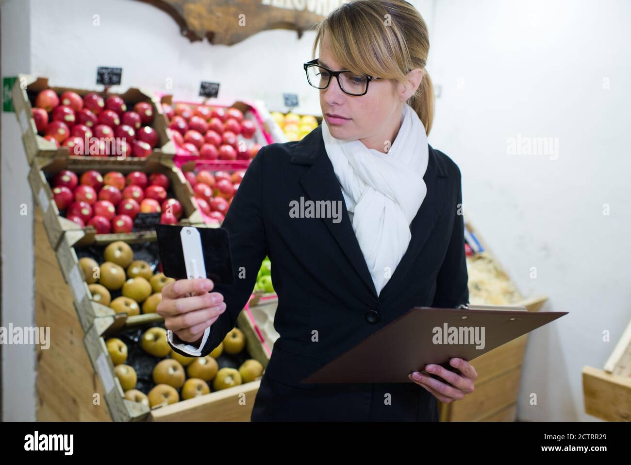 price controller looking at tag Stock Photo Alamy