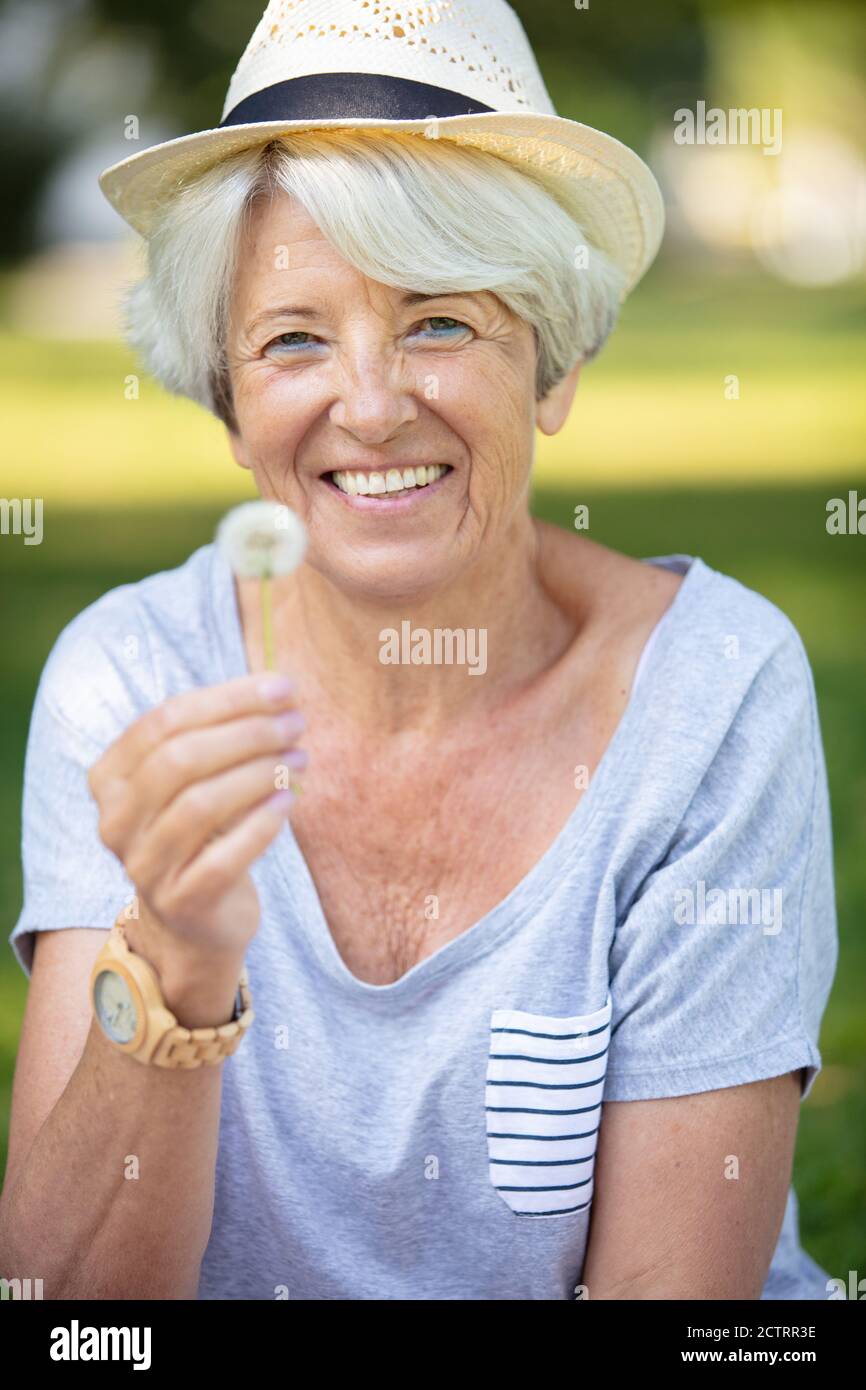 Senior woman holding dandelion hi-res stock photography and images - Alamy