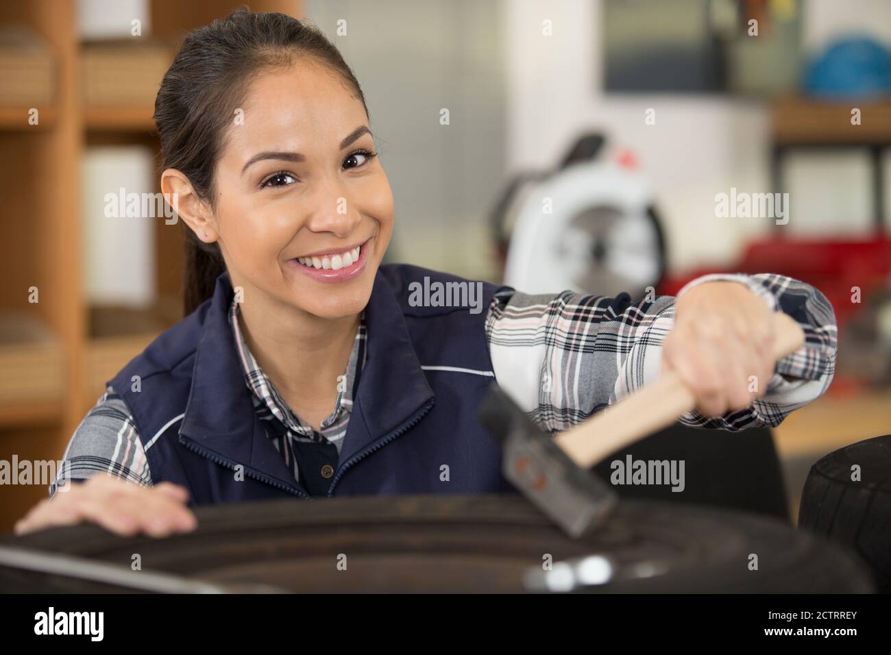 female mechanic using hammer on a car wheel Stock Photo Alamy
