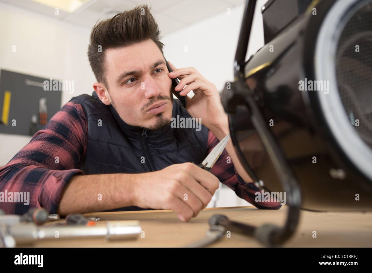 young technician working on broken computer in his office Stock Photo