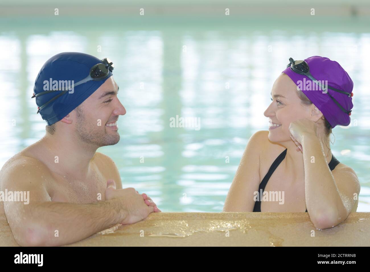 couple relaxing on the edge of a swimming pool Stock Photo - Alamy