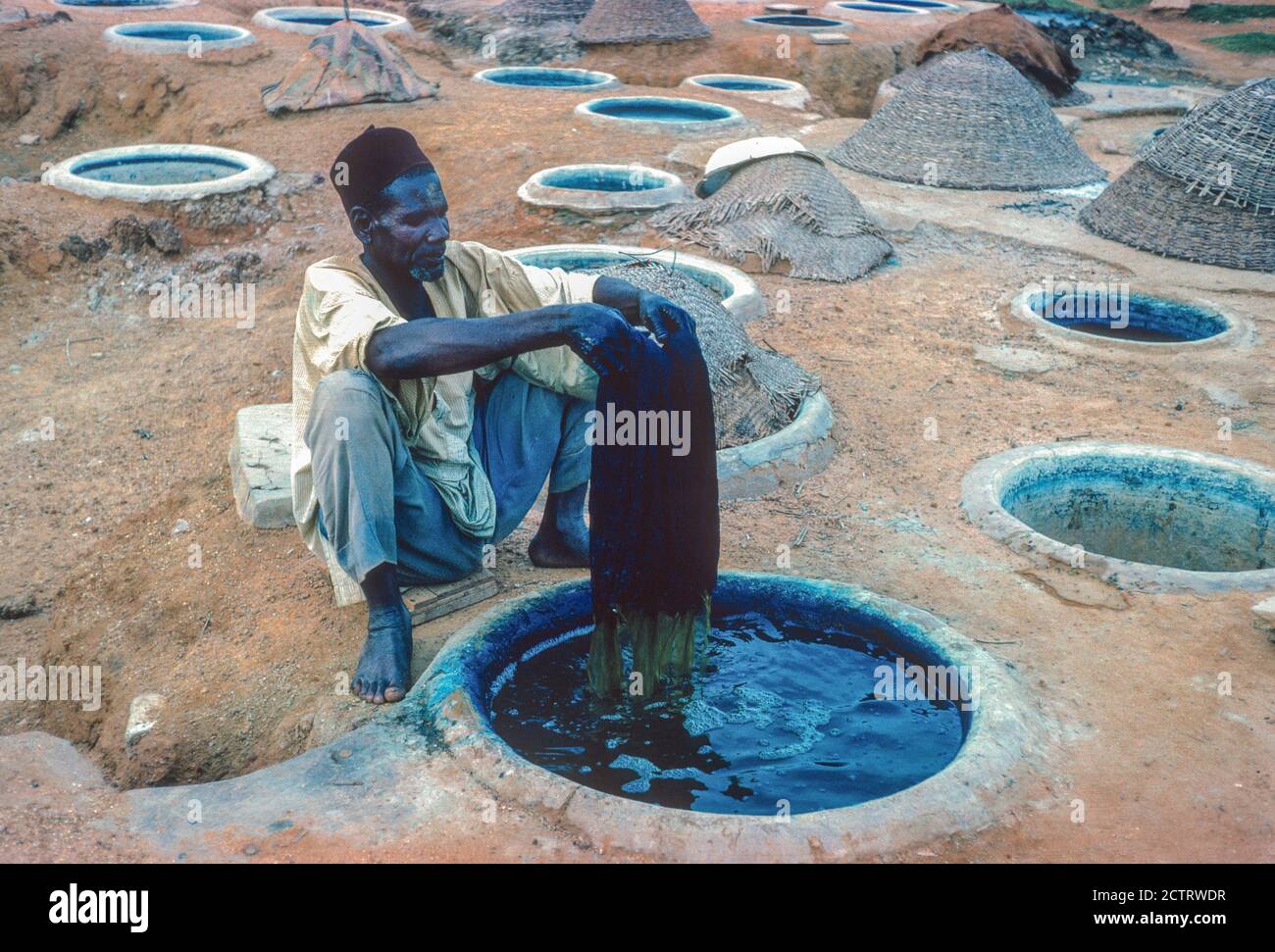 Kano, Nigeria. Dyer Dying Cloth in the Indigo Dying Pits of Kano