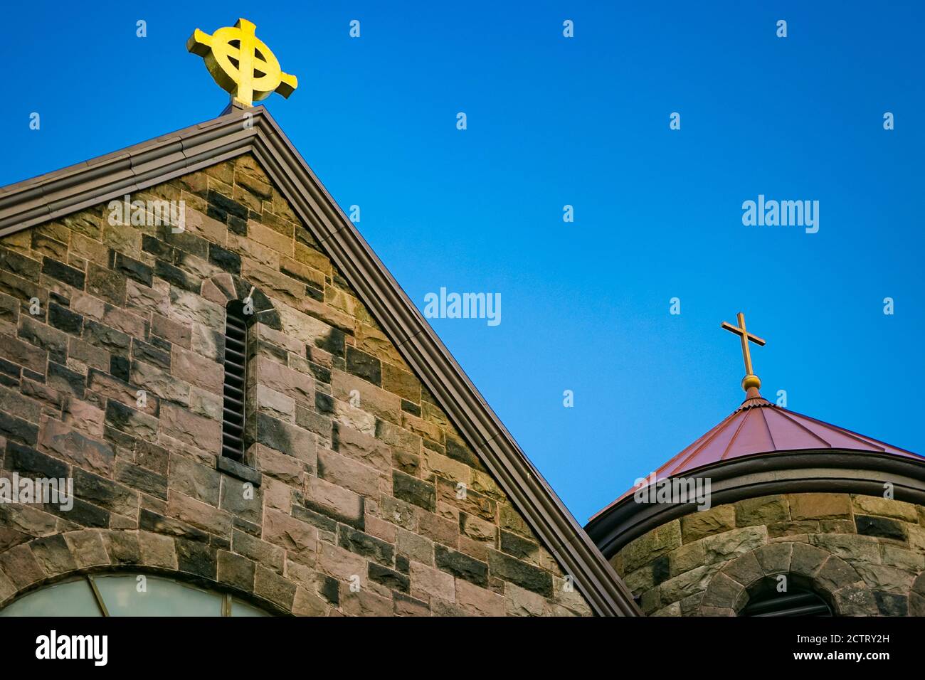 Various traditional crosses atop a stone house of worship Stock Photo