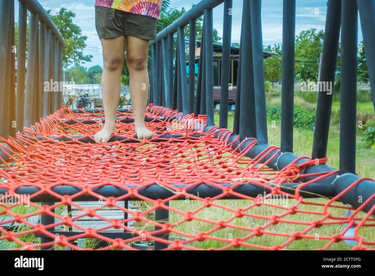 Swampy Rope Person crossing a rope bridge in the jungle hi-res stock photography ...