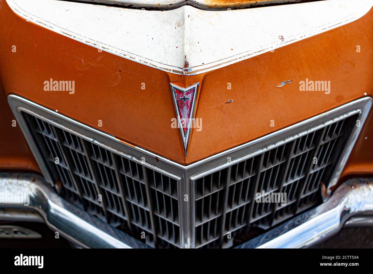 Rockville, MD, USA 09/12/2020: Close up image of the arrow head Pontiac car emblem on the front panel of an orange third generation Pontiac Grand Prix Stock Photo