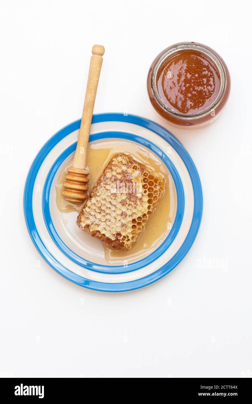 Honeycomb on a cornishware plate with a drizzler Stock Photo