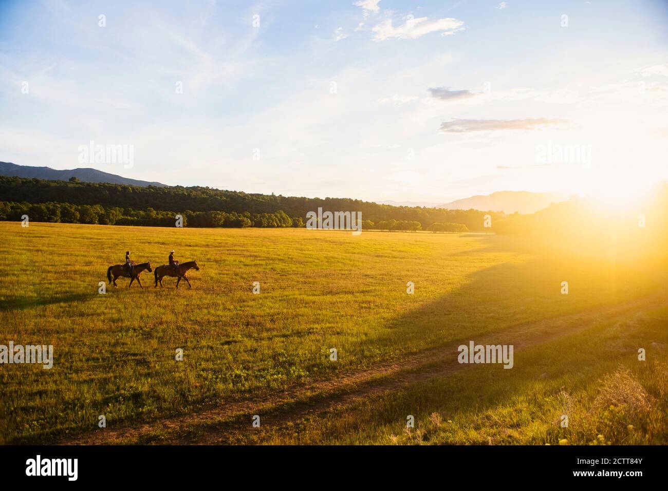 USA, Utah, Salem, Sisters (14-15) riding horses at sunset Stock Photo