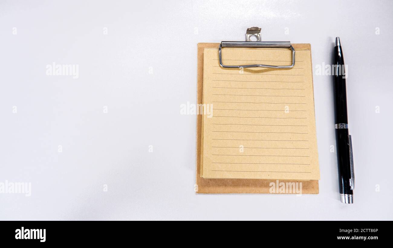 Notepad and pen on white office table Stock Photo - Alamy