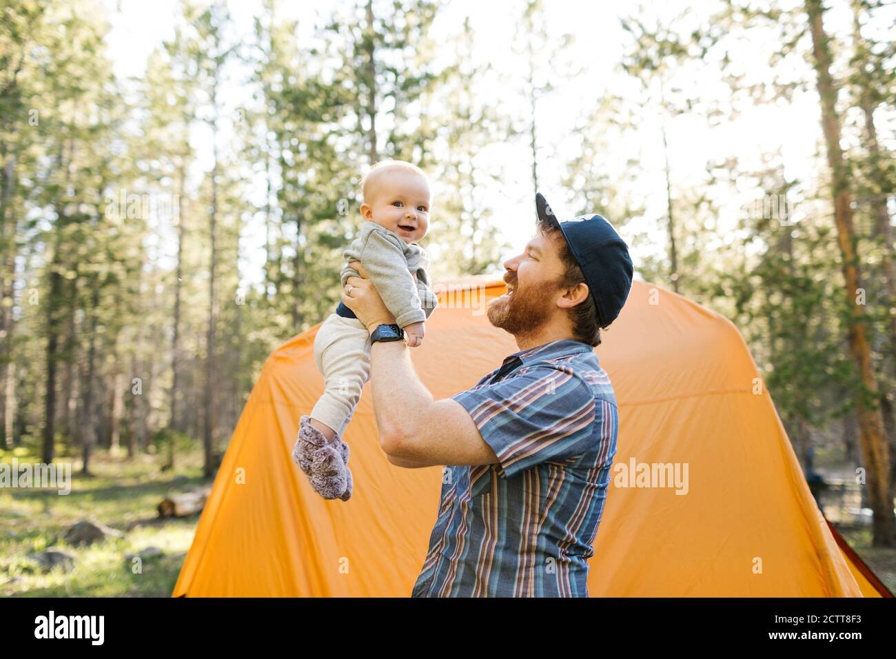 Father lifting baby boy(6-11 months) by tent in Uinta-Wasatch-Cache National Forest Stock Photo