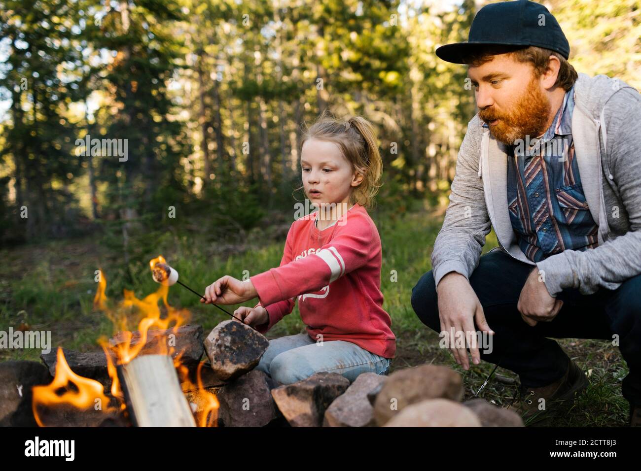 Man with daughter (6-7) roasting marshmallow above campfire, Wasatch Cache National Forest Stock Photo