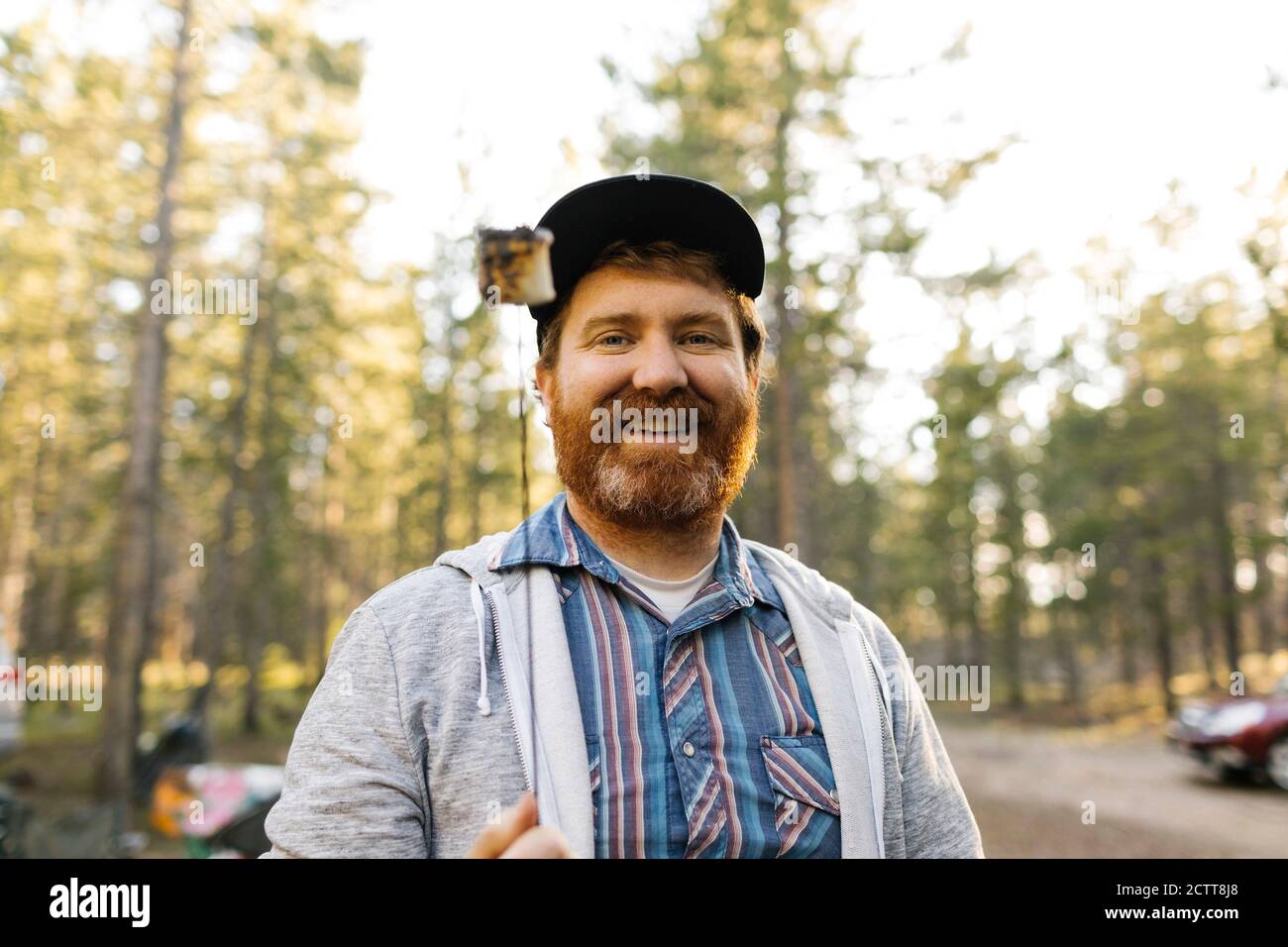 Portrait of smiling man holding roasted marshmallow on stick, Wasatch Cache National Forest Stock Photo