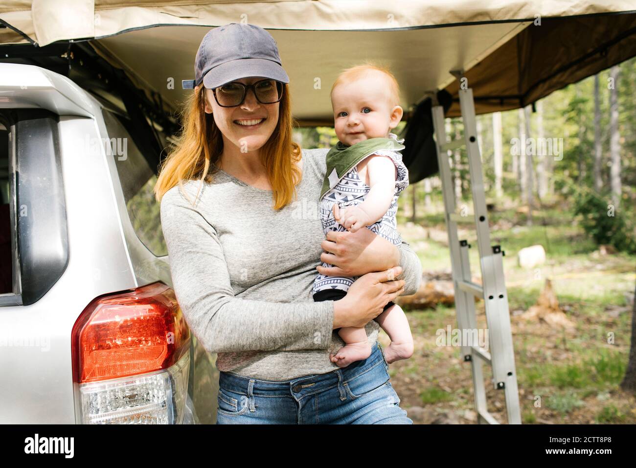 Portrait of smiling woman with baby son (6-11 months) on camping Wasatch-Cache National Forest Stock Photo