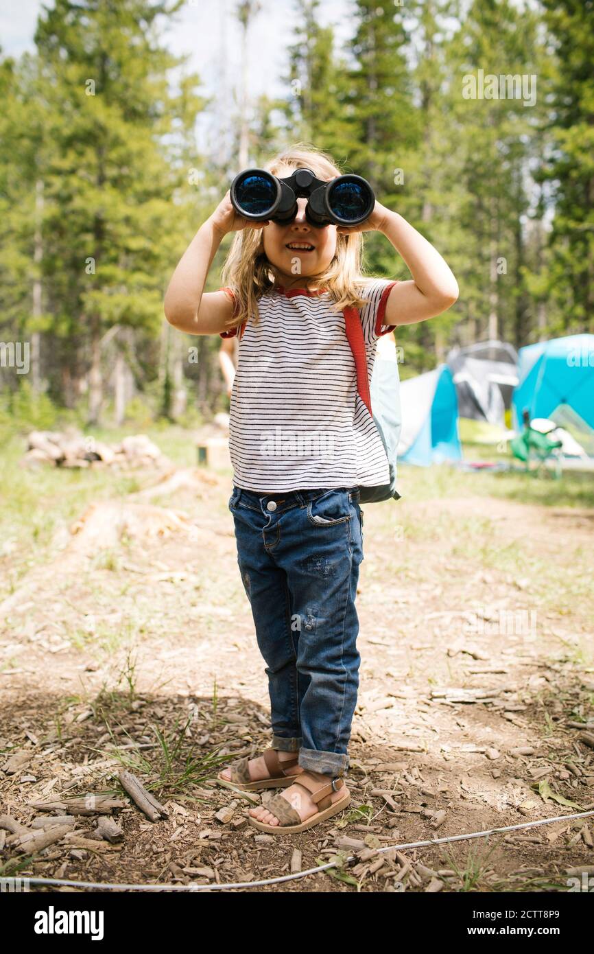 Girl (4-5) looking through binoculars in forest, Wasatch-Cache National Forest Stock Photo