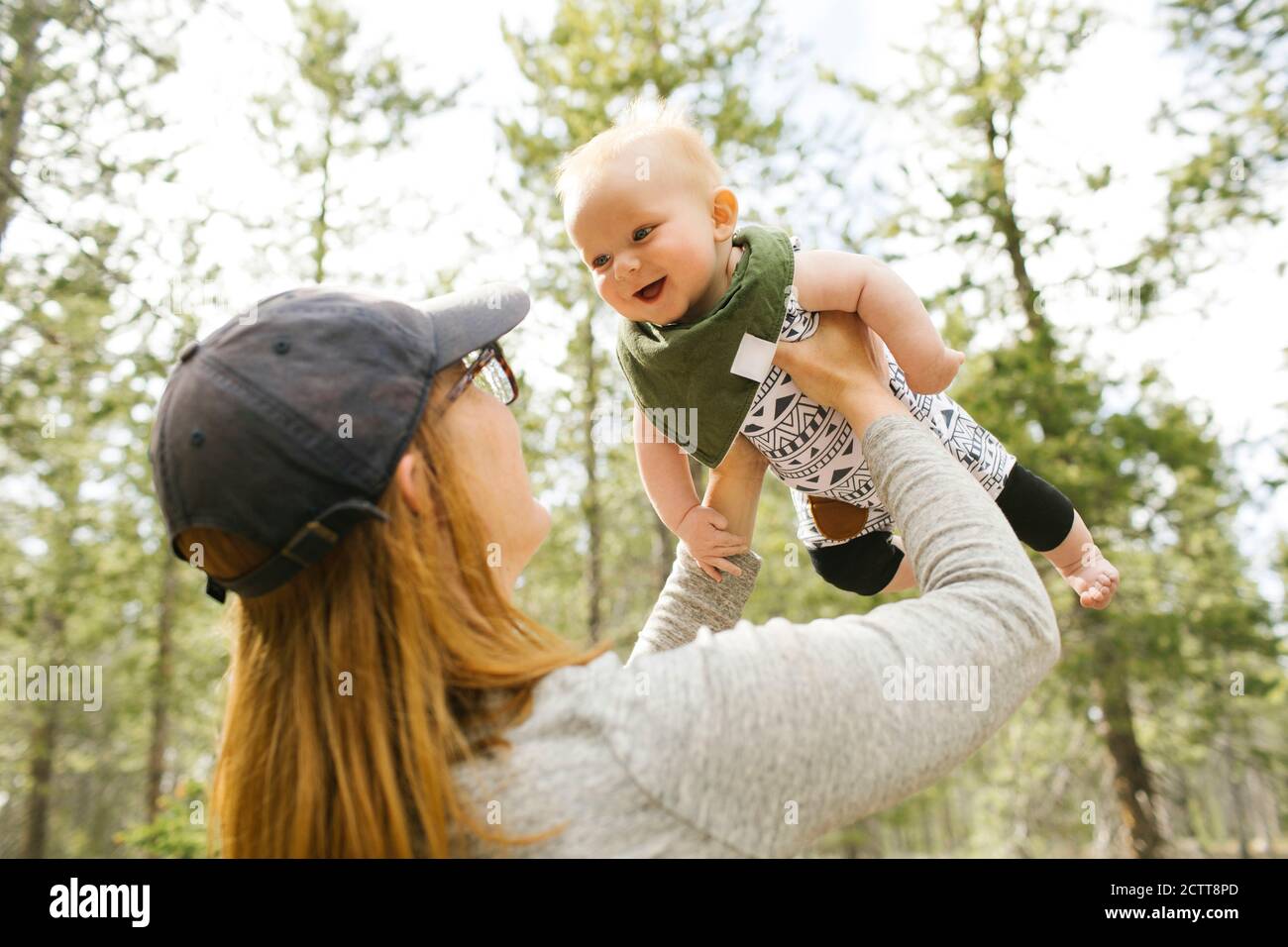 Smiling woman playing with baby son (6-11 months) in forest, Wasatch-Cache National Forest Stock Photo