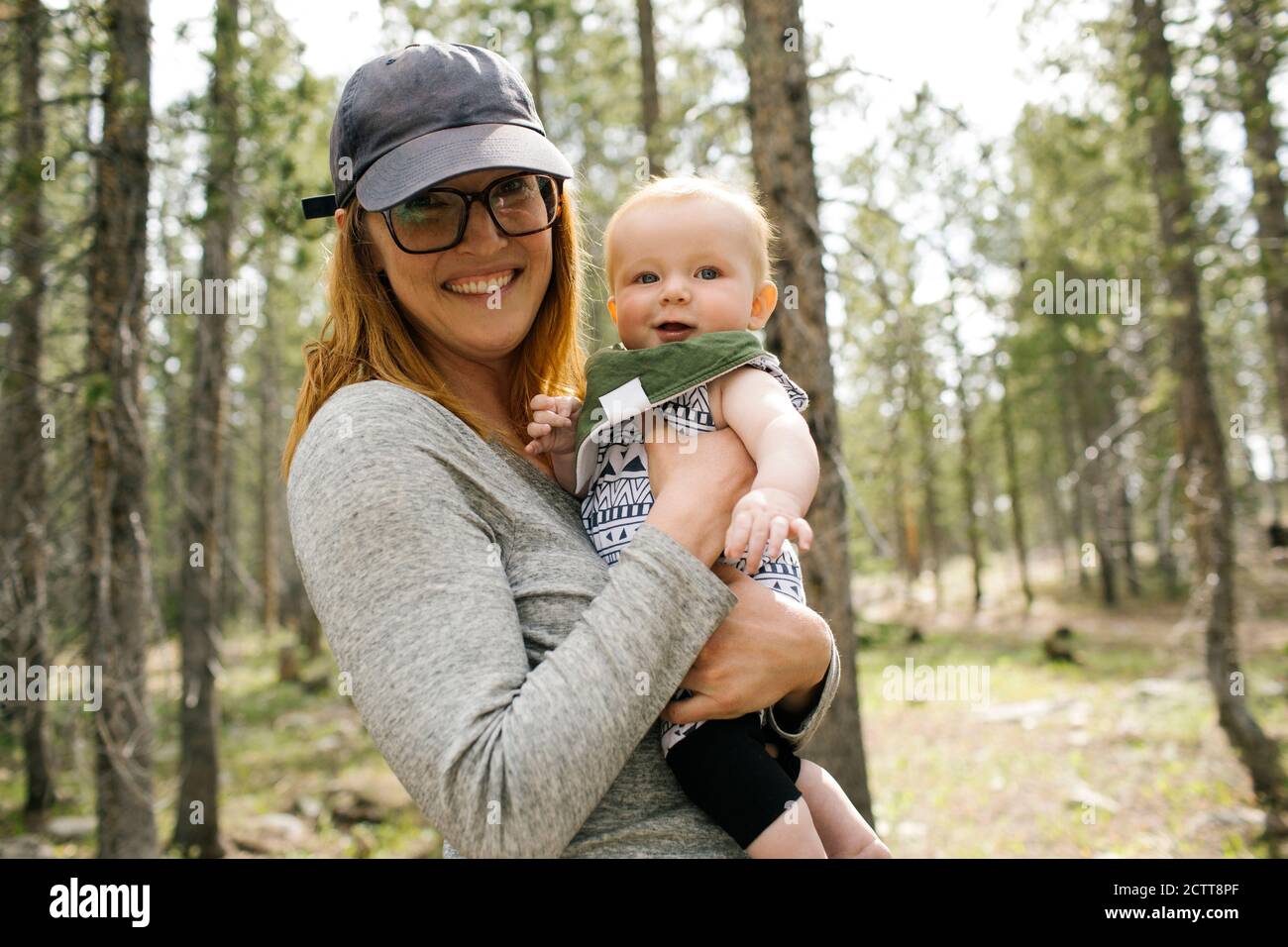 Portrait of smiling woman with baby son (6-11 months) in forest, Wasatch-Cache National Forest Stock Photo