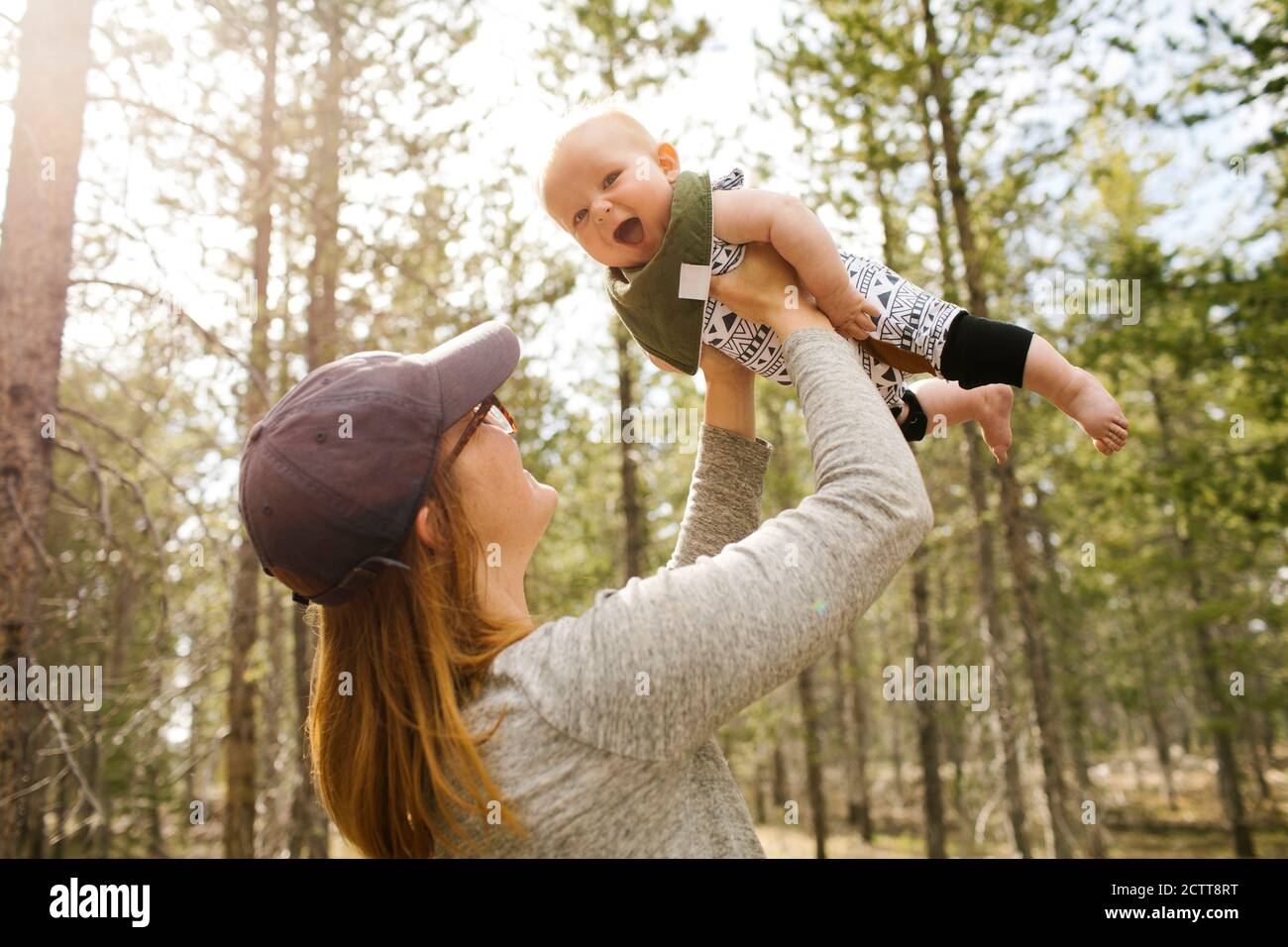 Woman holding baby son (6-11 months) in forest, Wasatch Cache National Forest Stock Photo