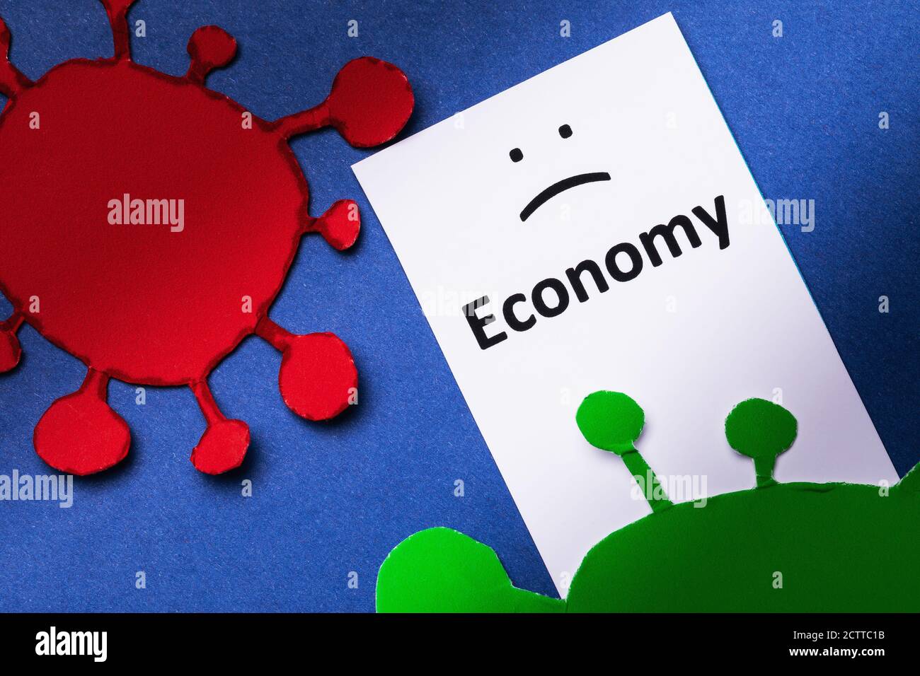 Label with text and paper figurines in the shape of the covid-19 virus. Concept on the theme of the impact on the economy of the coronavirus Stock Photo