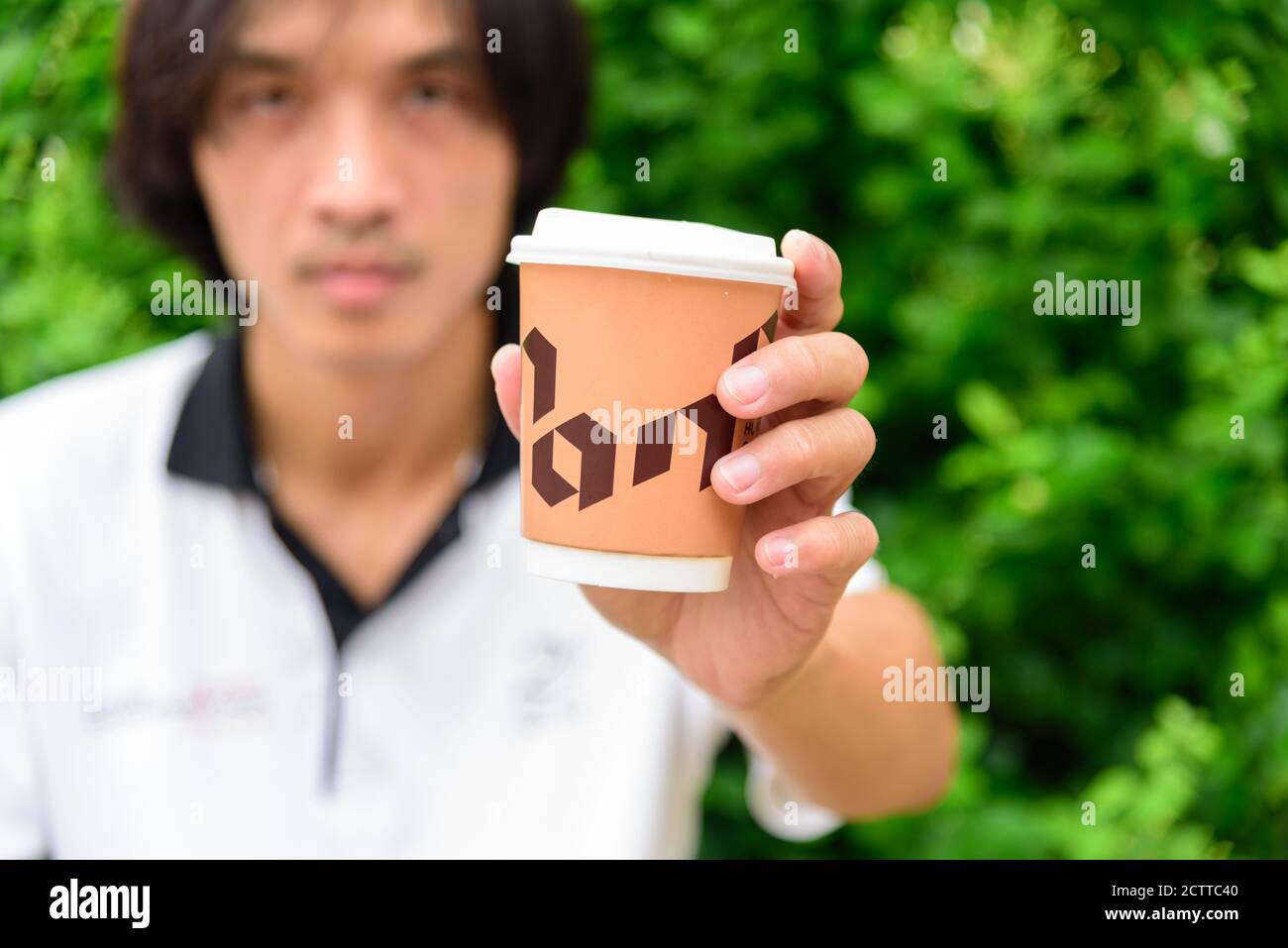 Bangkok, Thailand - 16 September, 2020:  The man hand show a cup of hot coffee of NANA Hunter Coffee Roasters coffee brand Stock Photo