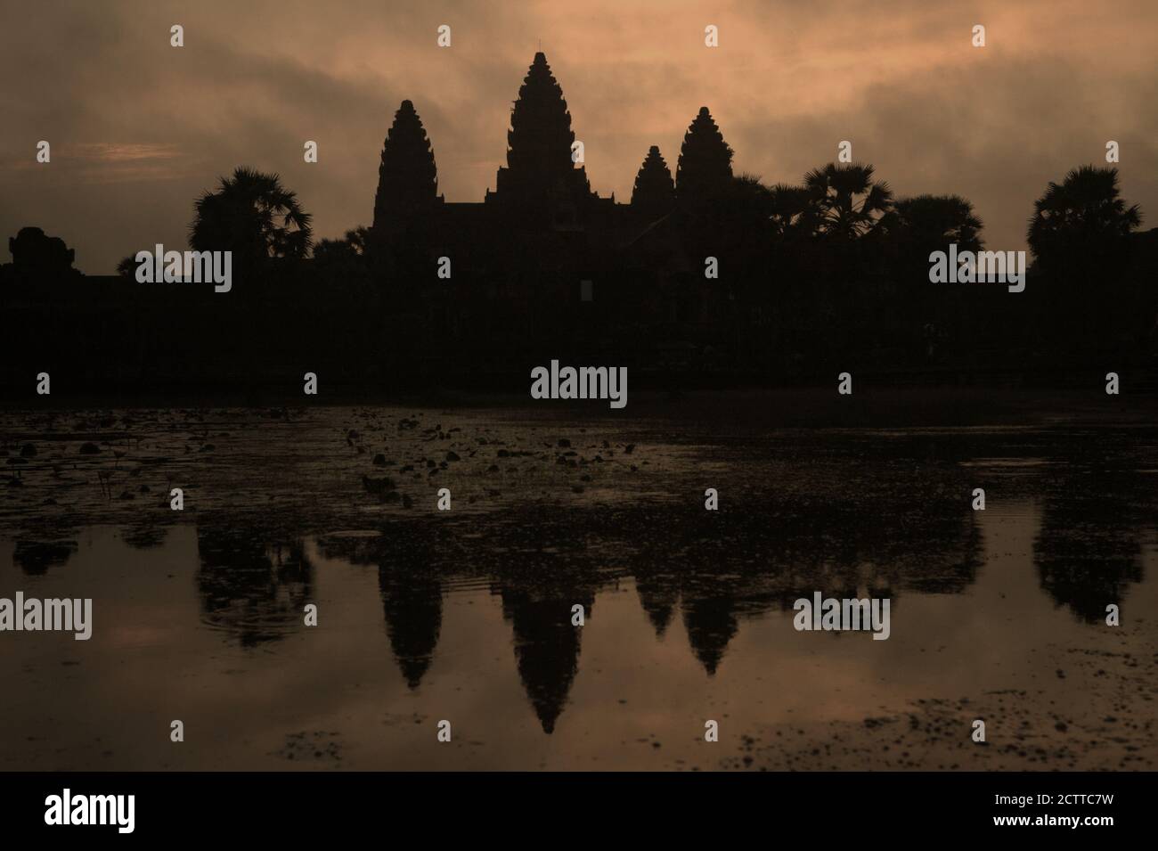 Angkor Wat silhouetted against the light on a cloudy morning. Stock Photo
