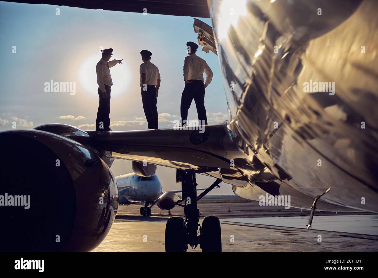 Image of part of aircraft standing in the airport with flight staff