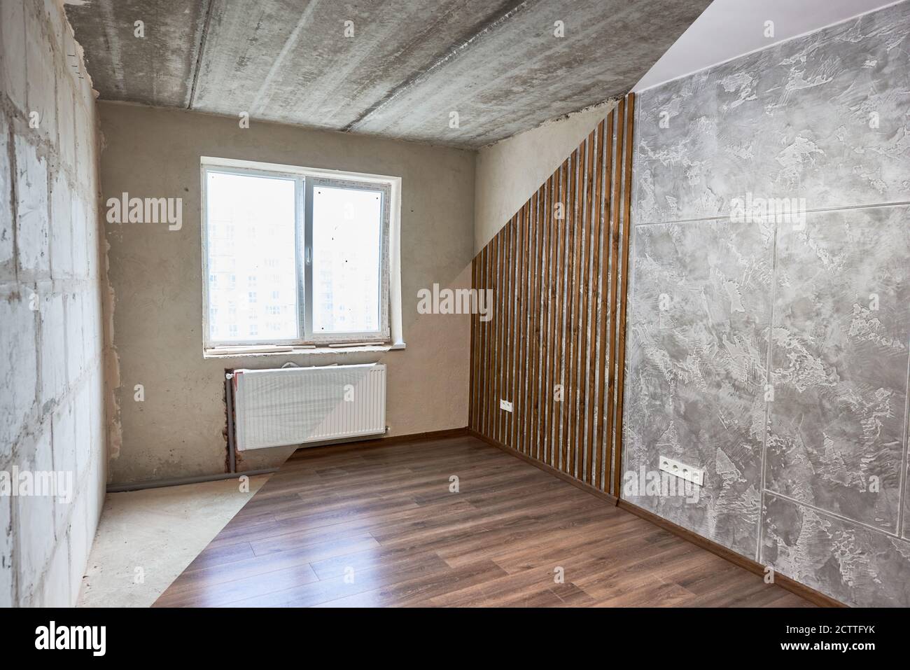 Comparative image of room before and after repairs. Unfinished walls made of blocks, ceiling vs shiny finished walls and wood floor. Concept of home restoration and renovation. Stock Photo