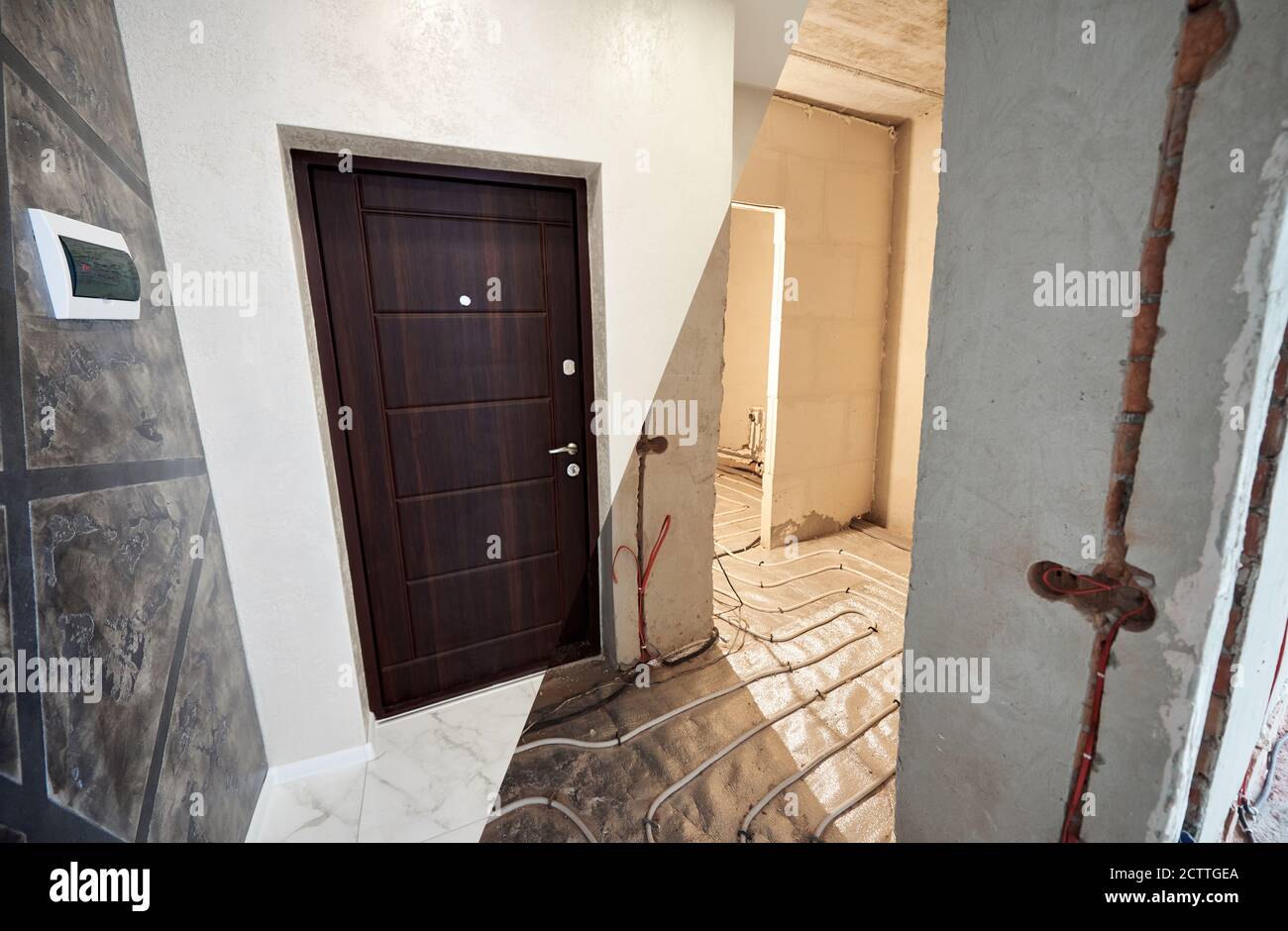 Modern apartment with front door before and after renovation. Comparison of old flat with underfloor heating pipes and new place with marble floor and brown entrance door. Stock Photo