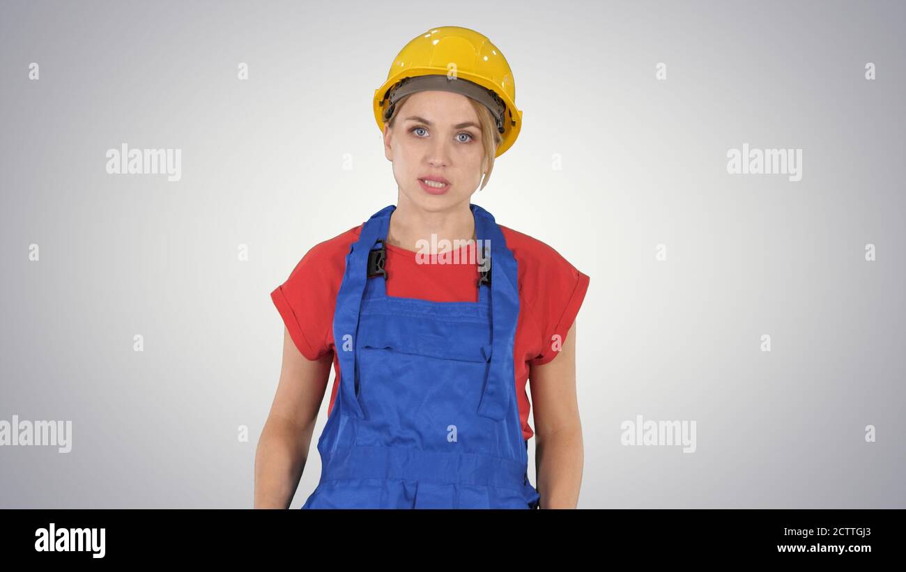 Woman in construction outfit talking to camera while walking on Stock Photo