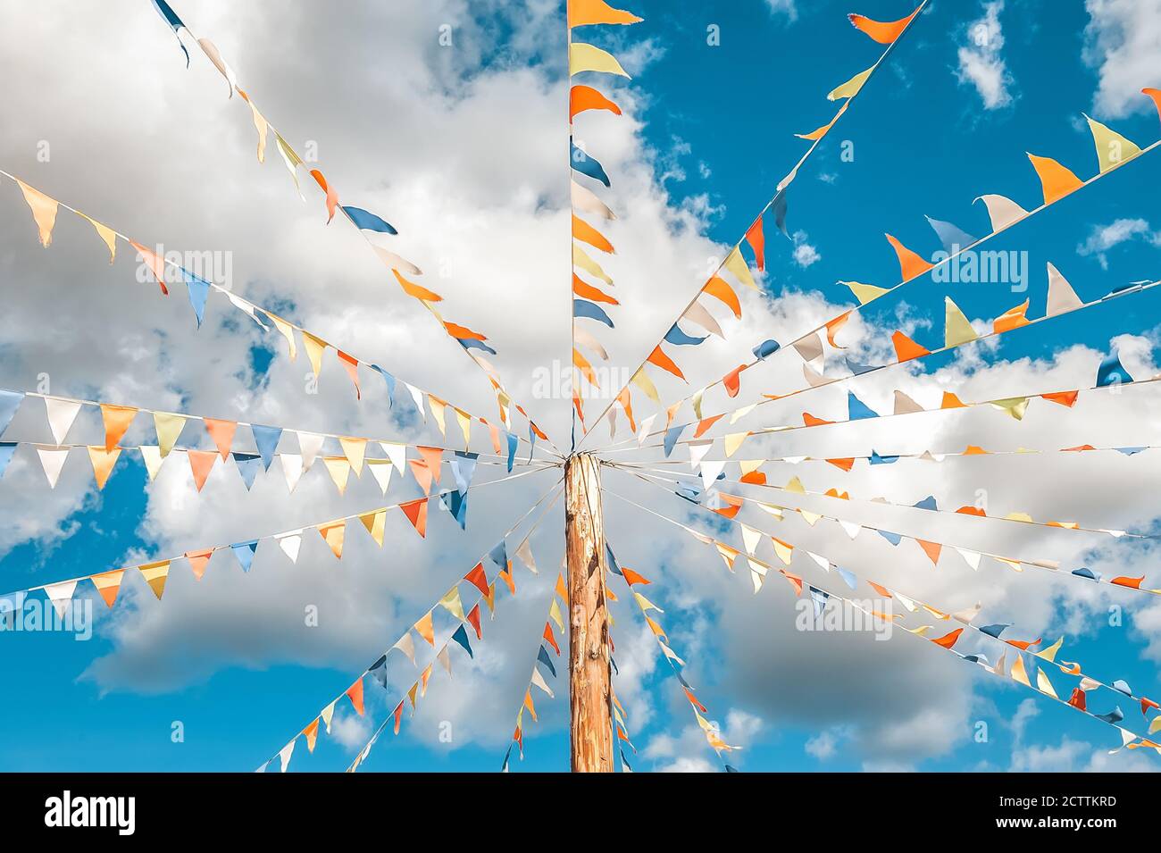 Colorful bright triangular Bunting flags on a blue sky background with ...