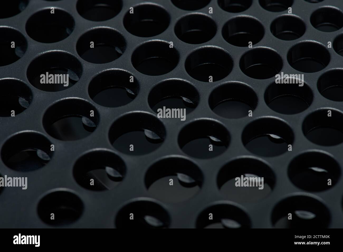 Holes in black matte surface macro close up view Stock Photo