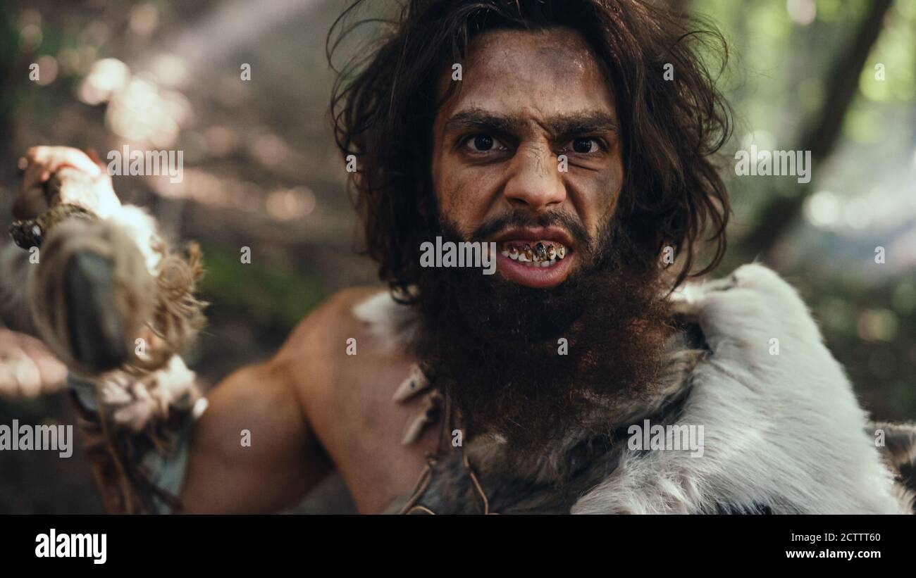 Portrait of Primeval Caveman Wearing Animal Skin and Fur Hunting with a